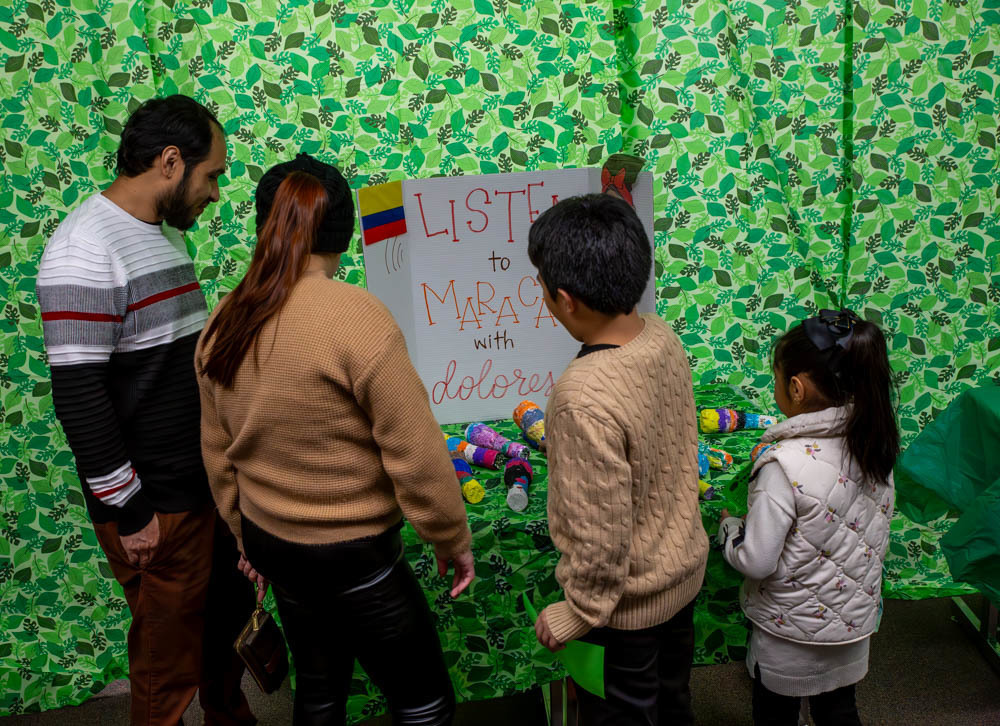 Two adults and two children look at one of the decorated presentations.