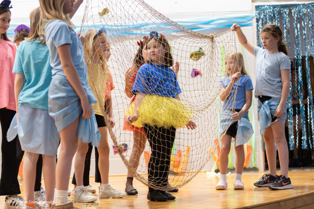 Student dressed as Dory behind a fishing net