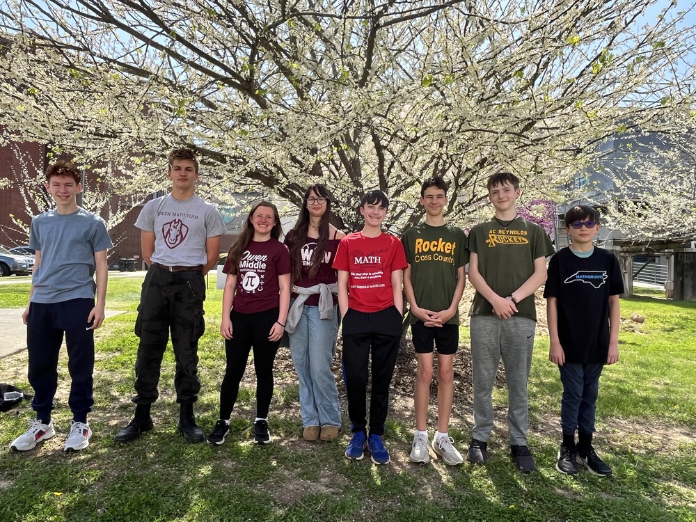 8 students who attended the state MathCounts competition stand in front of a tree in Durham.