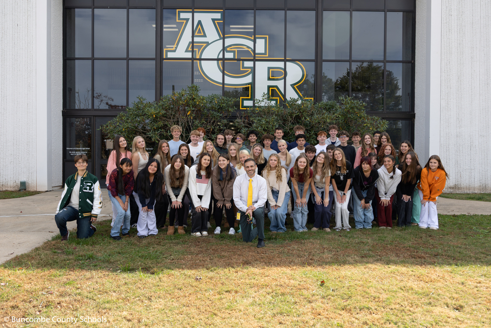 Ben Alexander and a group of students in front of the school. 