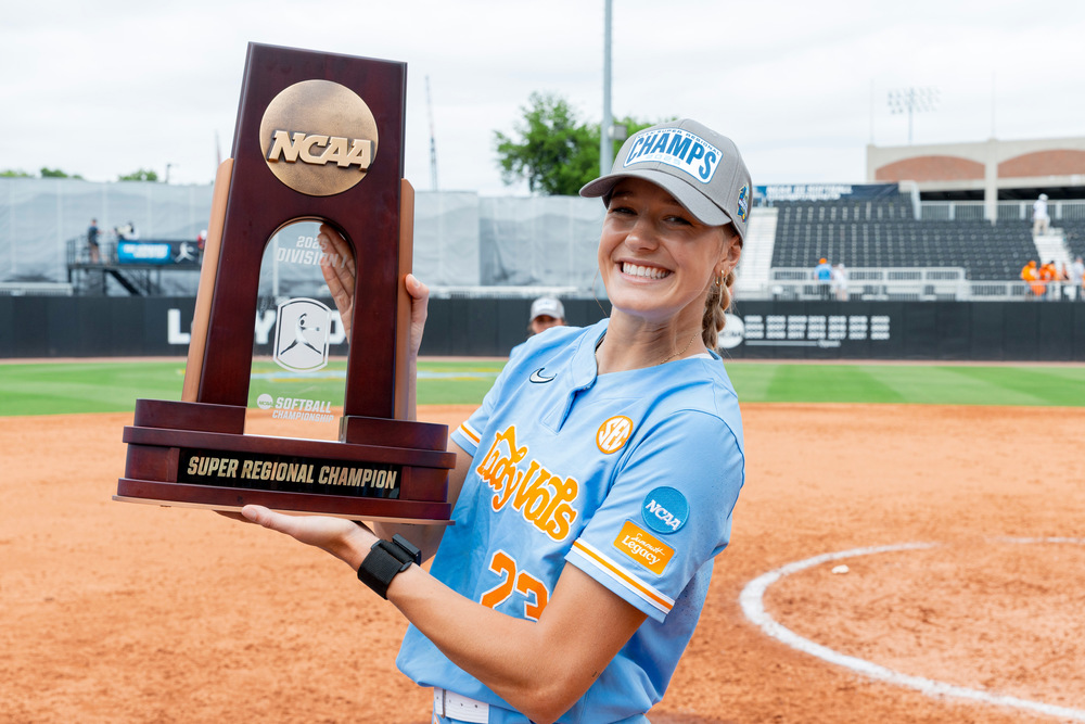 Karlyn Pickens holding an award that says Super Regional Champion. 