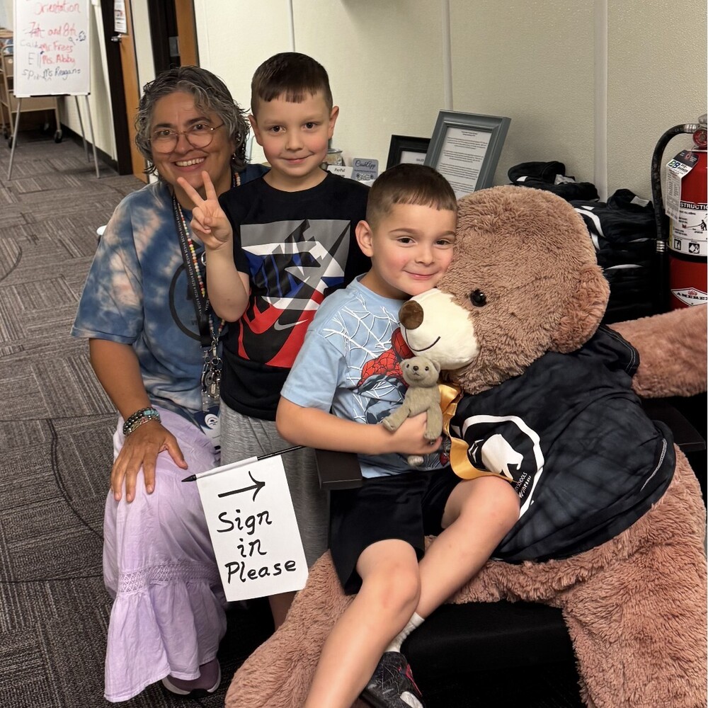 Ms. Ransom with 2 students and a bear