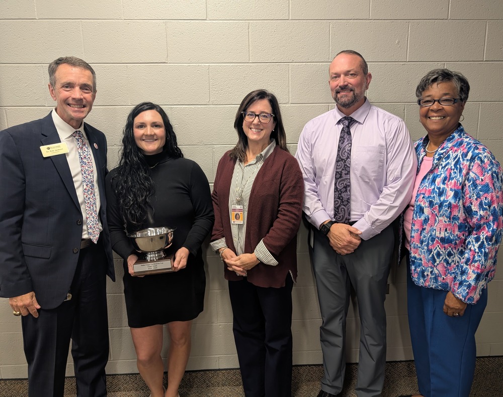 Dr. Jackson, Owen High Athletic Director Nikki Roland, Owen Principal Dawn Rookey, Owen Assistant Principal Nathan Padgett, NCHSAA Commissioner Que Tucker pose for a photo. Ms. Roland is holding a silver trophy, the "Wells Fargo Cup".