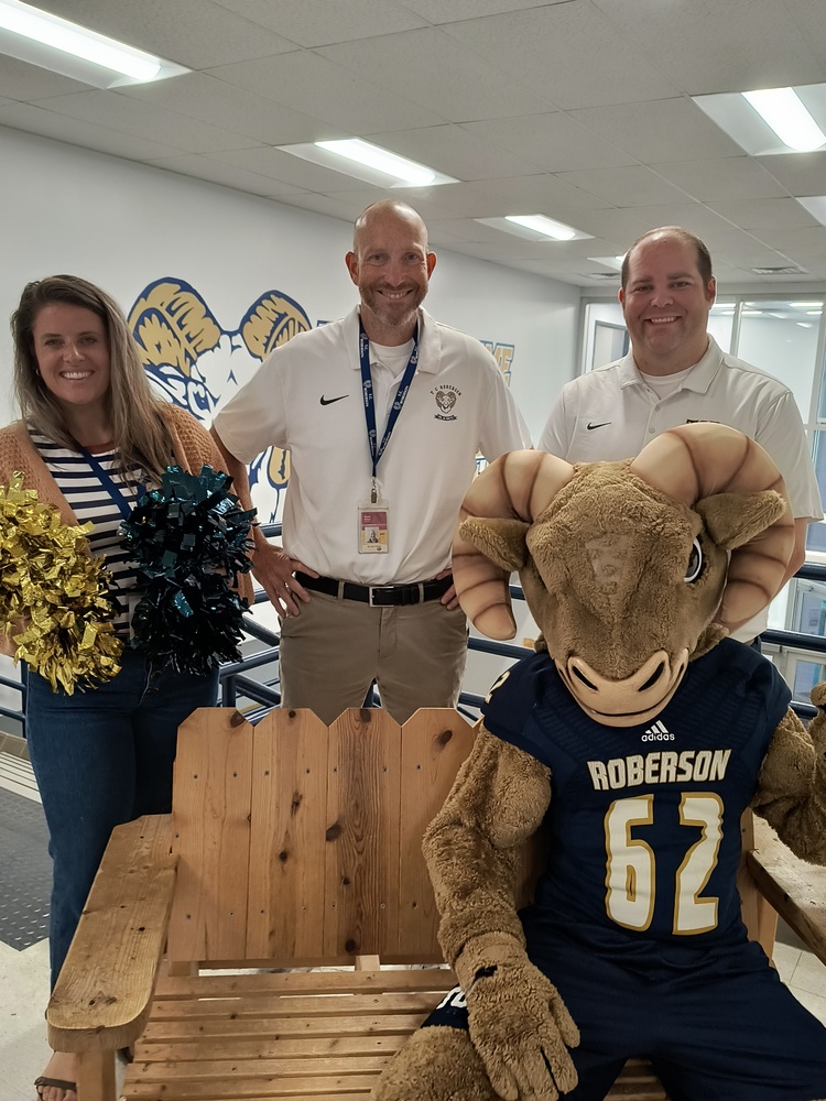 Athletic Administrators and Tommy C. Ram sitting on a bench