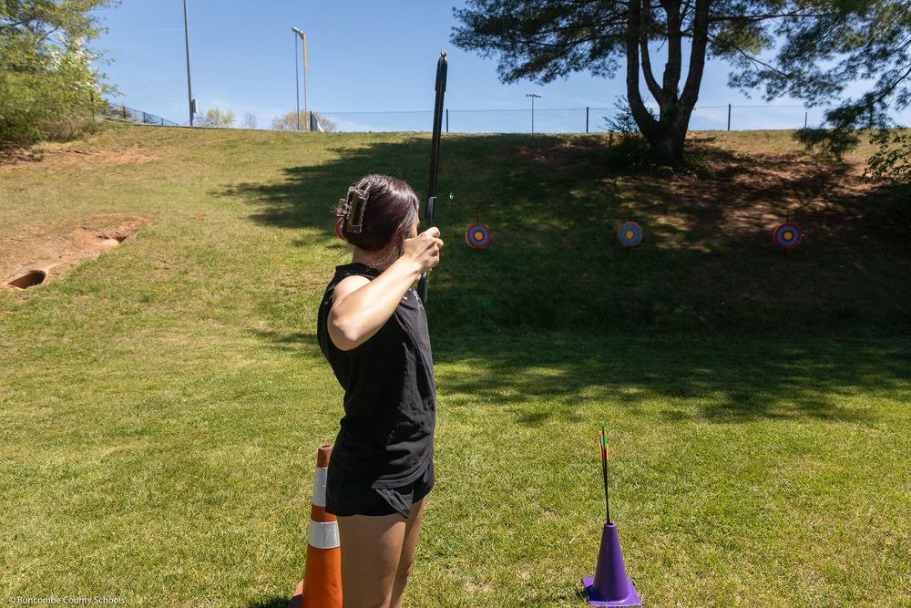 A student fires an arrow at a target.