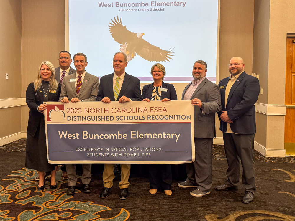 NAESPA representatives join Dr. Jackson, Mr. Johnson, and Ms. Yates behind a WEST BUNCOMBE ELEMENTARY - DISTINGUISHED SCHOOL RECOGNITION banner
