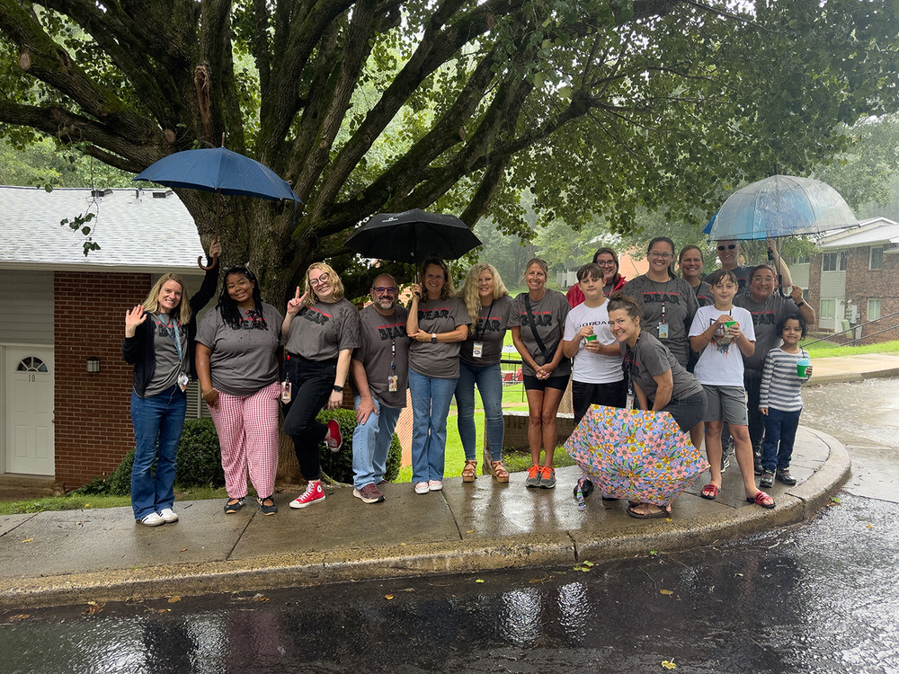 Johnston Elementary teachers and students posing together in the rain for a group photo. 