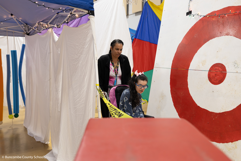 Staff member and student going through the maze at PEP.