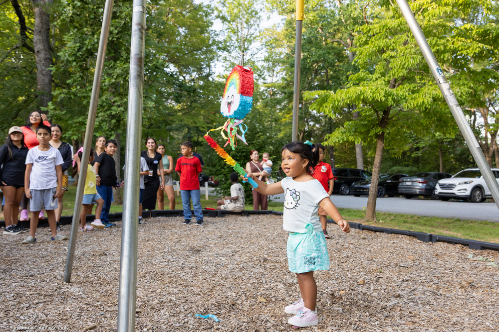 A girl swings at a pinata.