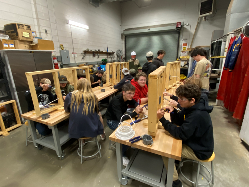Students seated at stations in North Buncombe High School's Electrical class. They are using wiring.