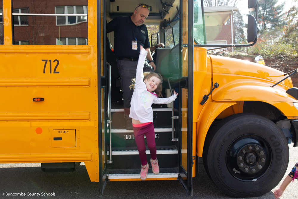 Little Girl Jumping off steps of bus