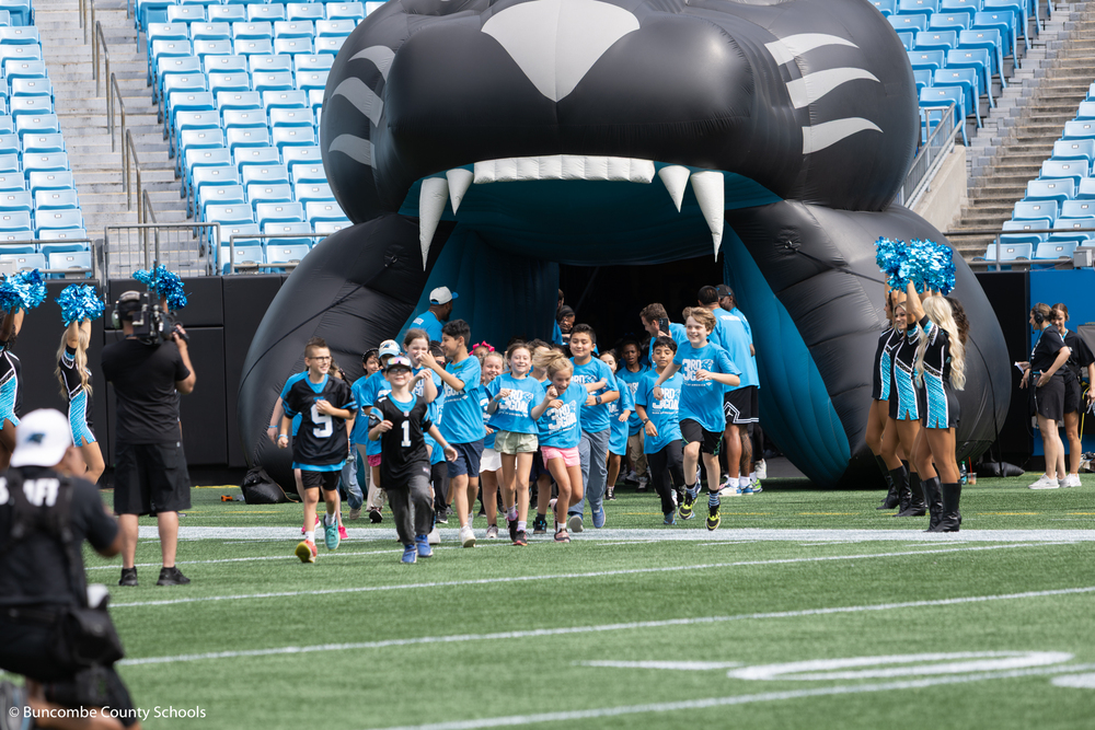 Students running onto the field at Bank of America Stadium
