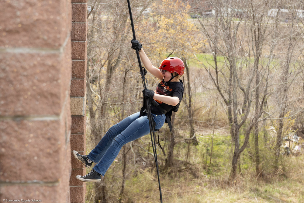 A student rappels down the tower.