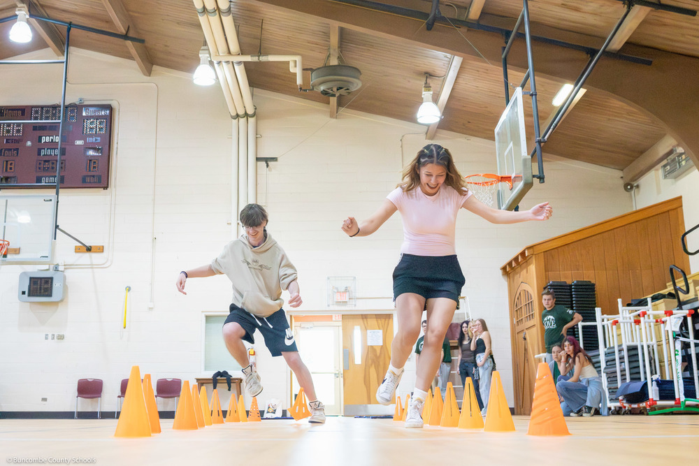 Two students run on an obstacle course.