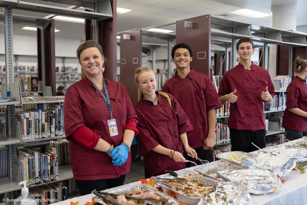 The Owen high foods and consumer science class posing behind the buffet ling posing for a photo. 