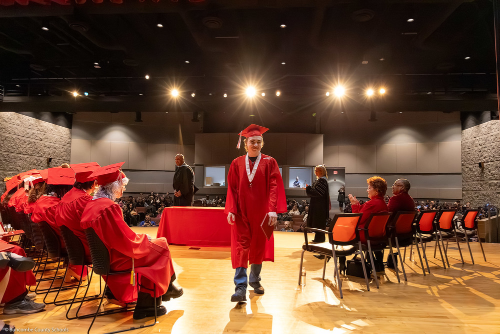 A student walks toward the camera at Erwin High's mid-year graduation ceremony.
