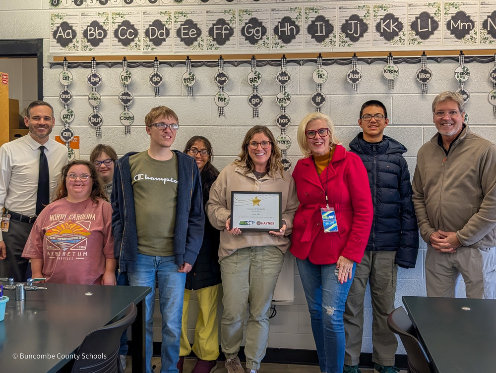 Mr. Alexander stands next to Ms. Choi's students. Ms. Choi and Melanie from Mix 96.5 are in the middle. Ms. Choi is holding her certificate.
