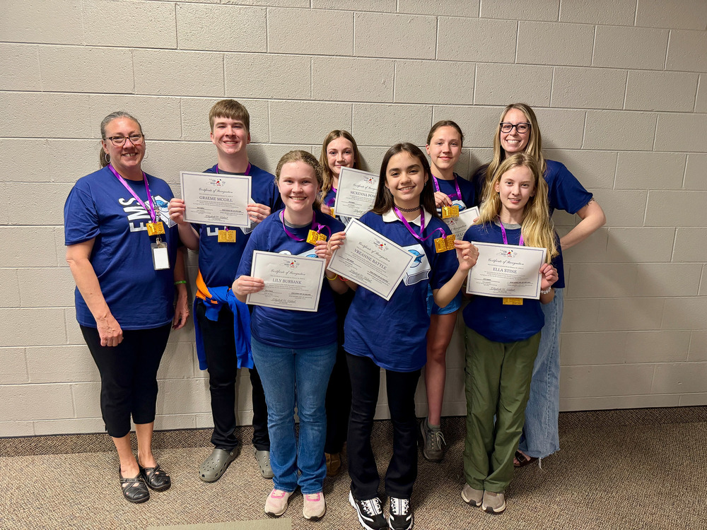 The winning Enka Middle team poses with certificates and medals.