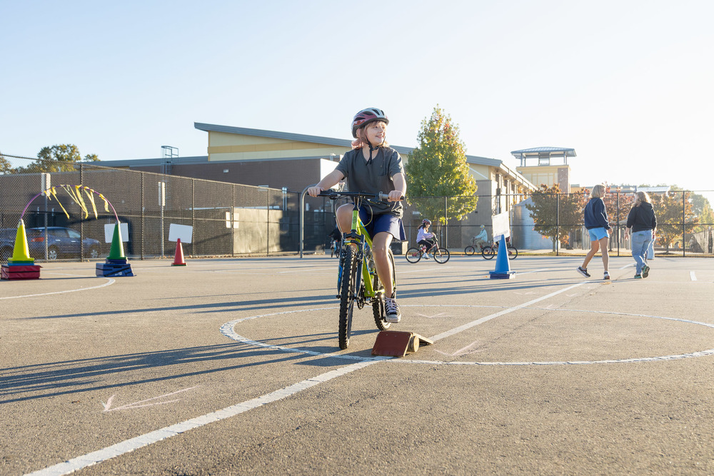 A student rides a bike on the school's blacktop.