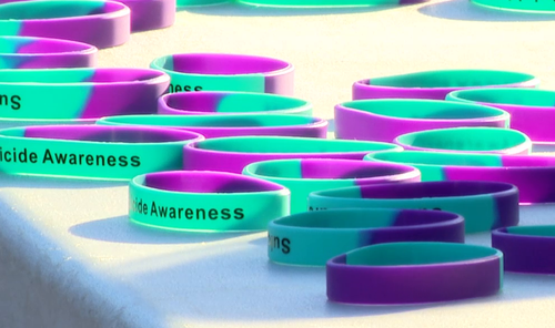 Green and purple Suicide Awareness bracelets  laid out on a white table.