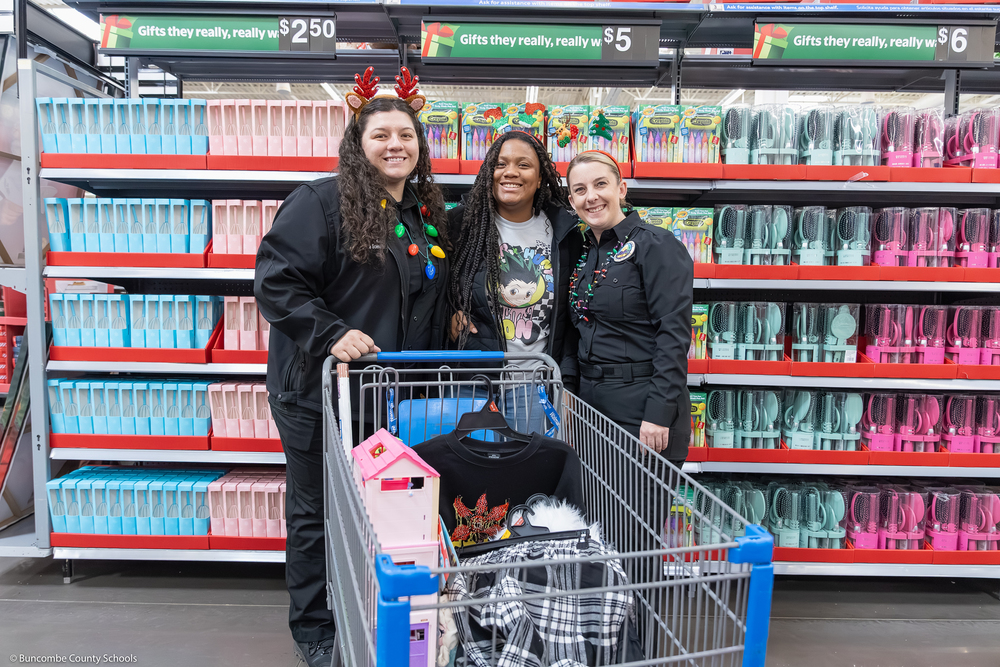 A middle school student poses with two sheriff's office employees.