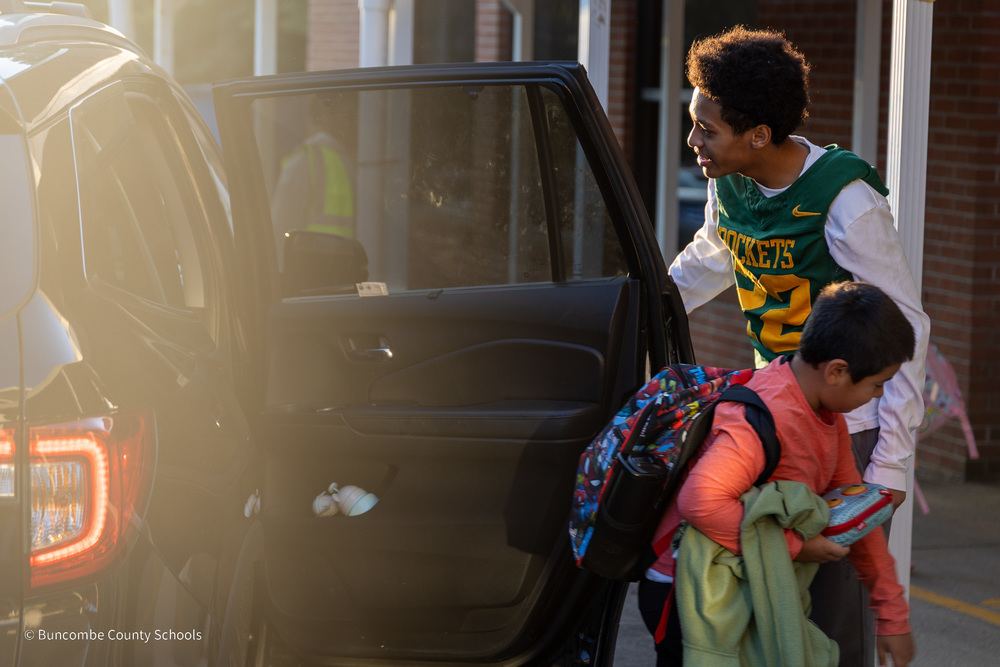 Reynolds football player holds the car door as a Haw Creek student exits the vehicle.