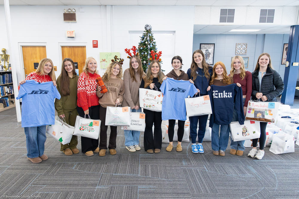 Enka High's SGA poses with bags and gift items.