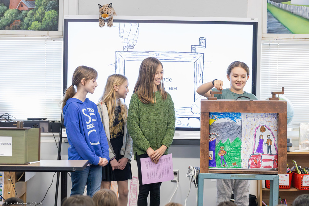 Four students demonstrate Oakley's crankie box.