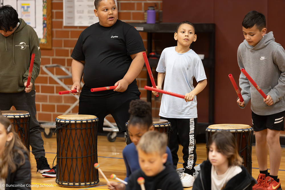 Group of students playing a variety of drums.