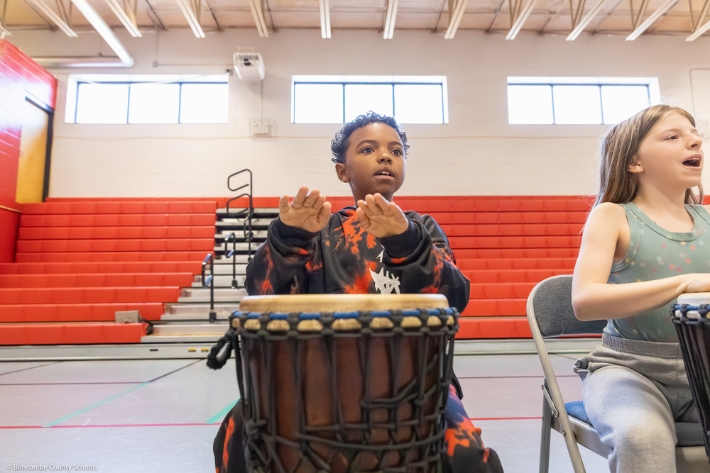 A student hits a floor drum.