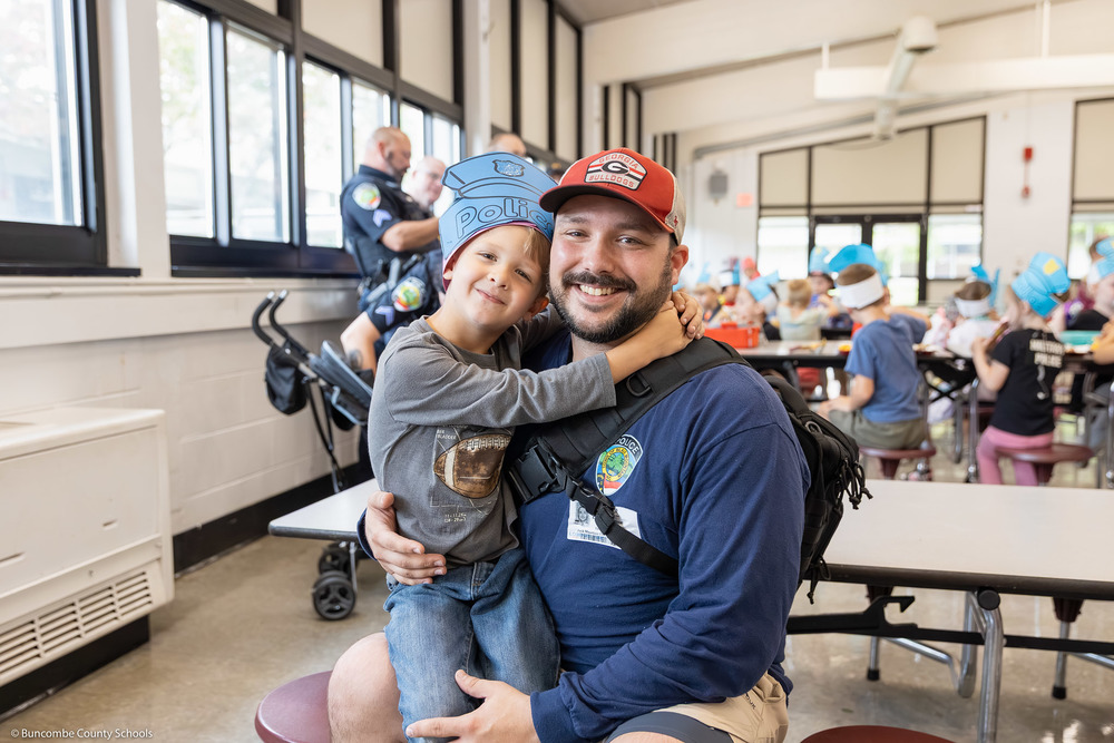 A police officer holds his son at Black Mountain Primary.