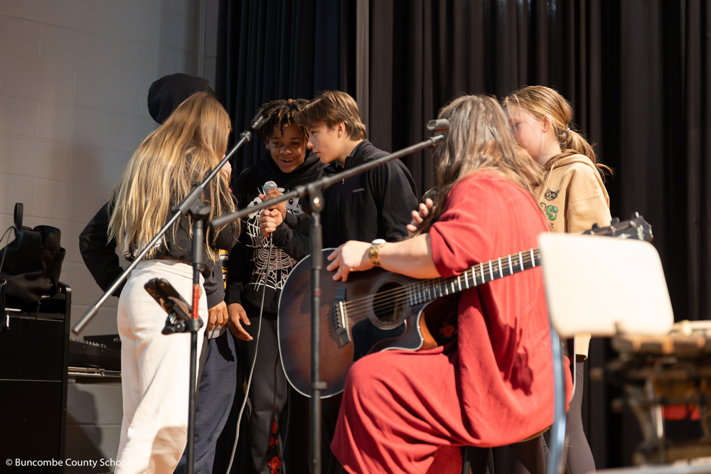 Students on stage singing with the KONO band. 