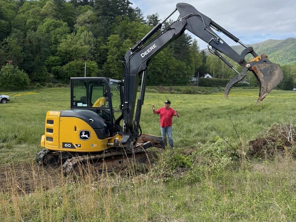A man speaks to a student sitting in a backhoe.