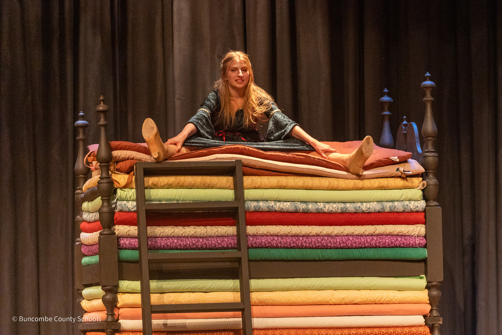 The princess sits atop 30 mattresses in a bed made for the set.