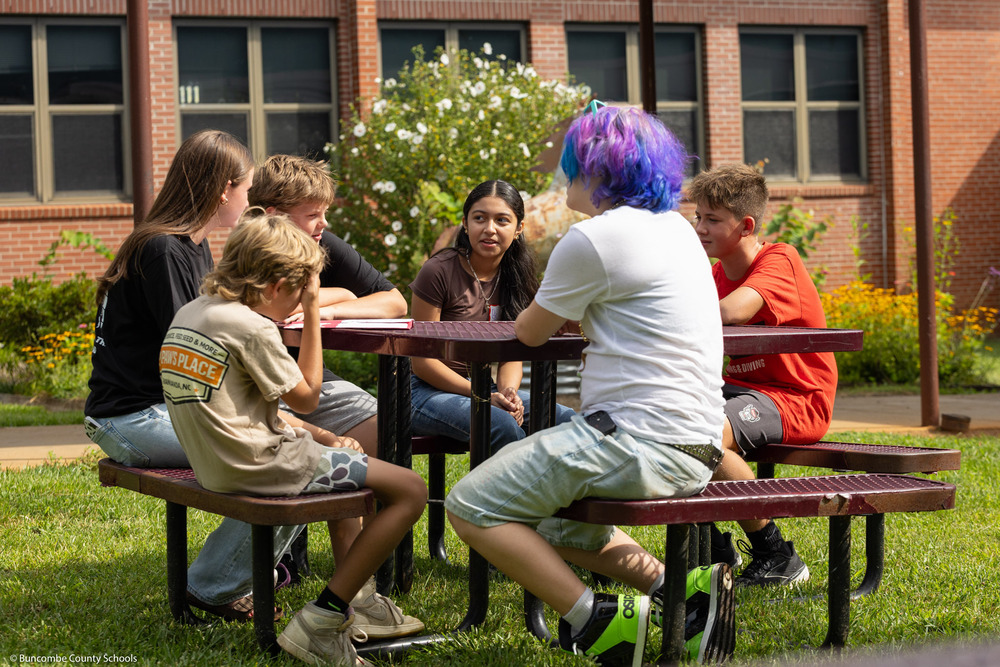 Eighth grade mentors talk to rising sixth grade students in the Owen Middle courtyard.