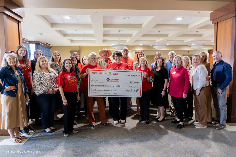 BCSF Board gatherd with ingles, iheart media, and kellanova employees holding a check for $10,000