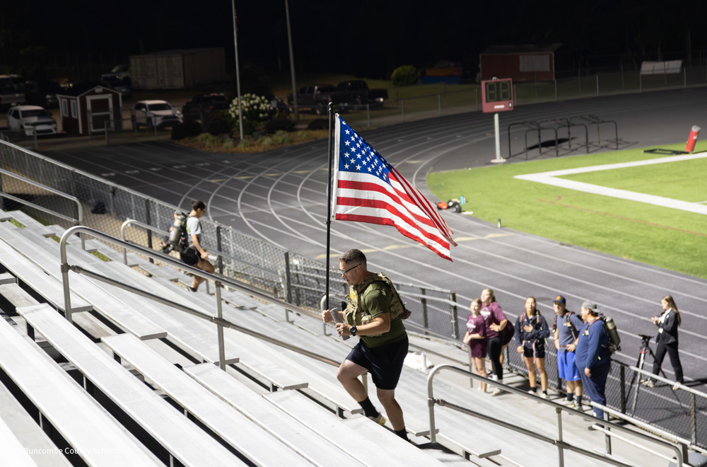 Owen SRO carrying American Flag up the stadium stairs