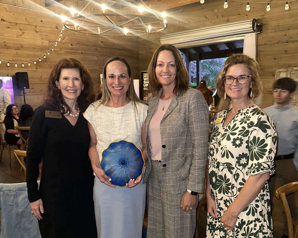 Ms. Erickson holds her blue bowl award surrounded by BCS teammates.