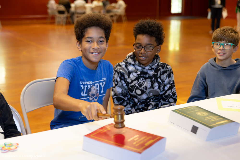 Kid hitting a gavel on a textbook. 