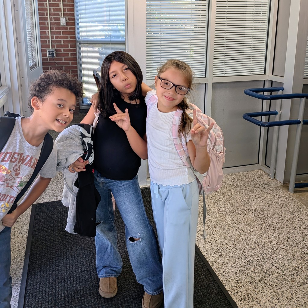 Students smile and hold up their Woodfin Wolverines symbol to celebrate finishing their first week of the school year!