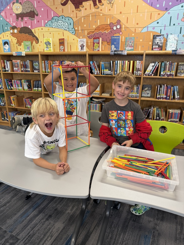 Students standing with straw tower
