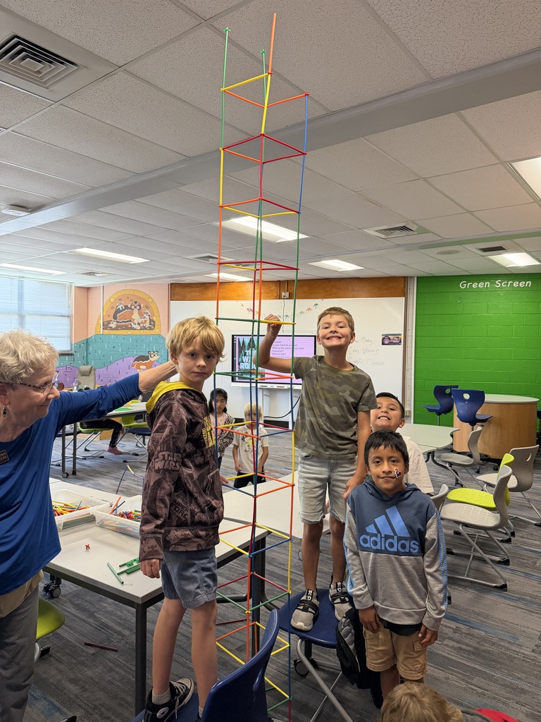 Students standing with straw tower