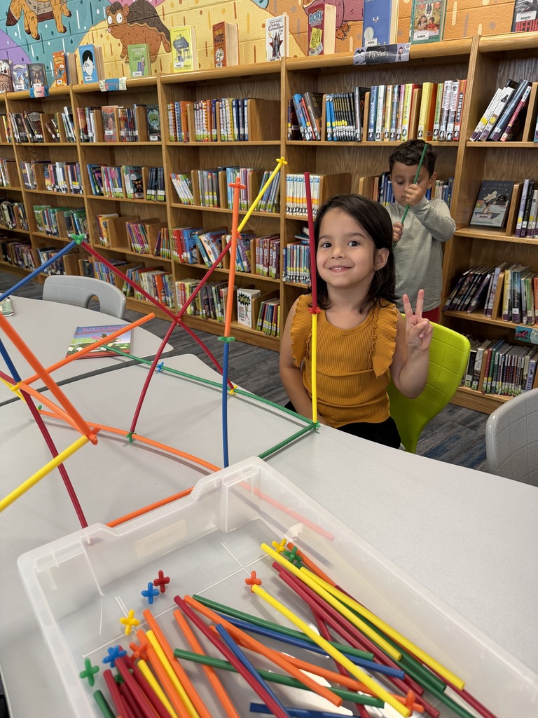 Students standing with straw tower