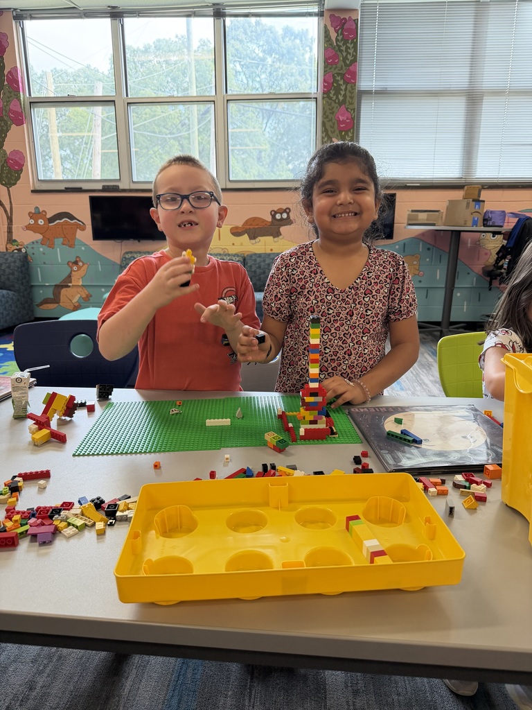 Students standing with lego build