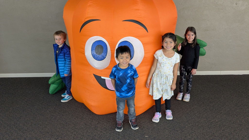 Students stand with blow up pumpkin