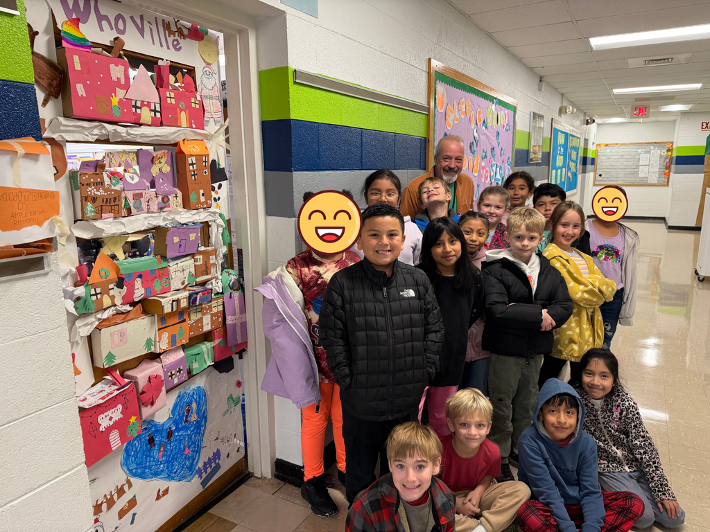 Third grade students stand beside their "Whoville" door smiling. 