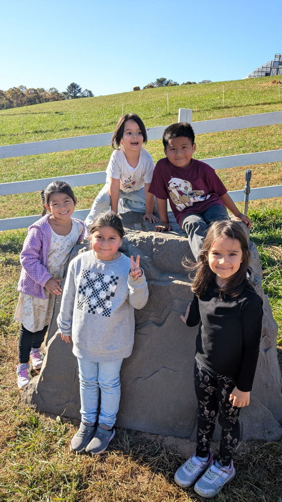 Kindergarten students posing with a boulder.