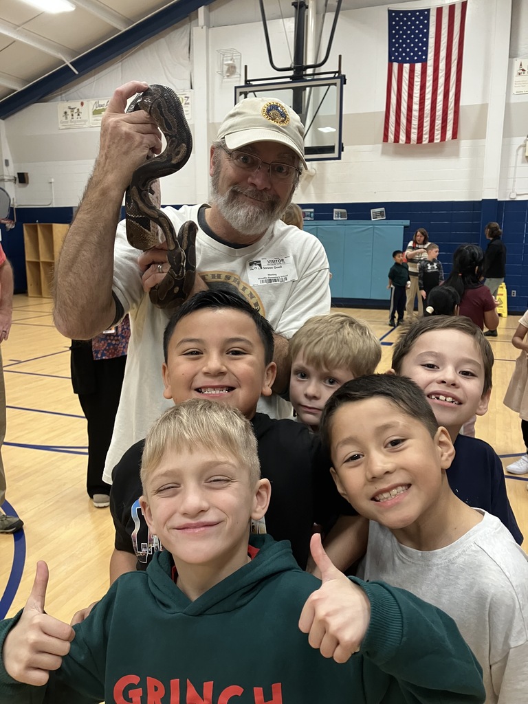 Man standing with snake and five students. 