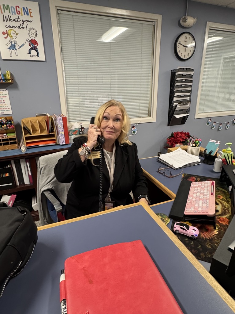 Ms. Plemmons answering phones at the Woodfin Elementary School front desk. 