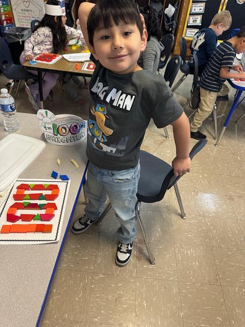Student smiling with 100 on her desk.